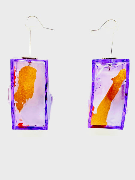 The Node Cube Earrings are made individually by Olga Alexander. Their fluorescent means that when they can be viewed in multiple ways, viewed from the front their surface is smooth and alluring but  when viewed from another way they reveal their raw color! No matter the colors they can be custom ordered at no extra charge!