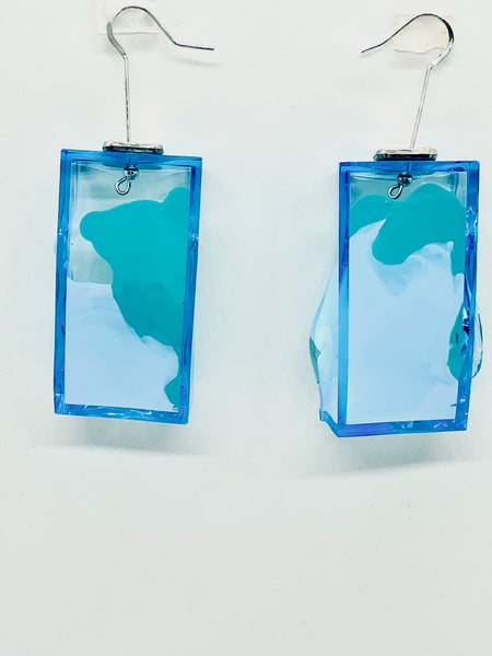 The Blue Drop Node Earrings are hand painted and molded by the artist to look like molted lava or melting ice cubes; they swivel too, to offer multiple options for wearability! Super lightweight and glowing with their transparent and fluorescent light they are not your ordinary costume jewelry! Drop approximately, 2.5 inches