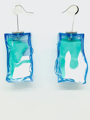 he Blue Drop Node Earrings are hand painted and molded by the artist to look like molted lava or melting ice cubes; they swivel too, to offer multiple options for wearability! Super lightweight and glowing with their transparent and fluorescent light they are not your ordinary costume jewelry! Drop approximately, 2.5 inches